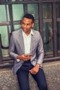 Young black Man texting on cell phone on street in New York City Royalty Free Stock Photo