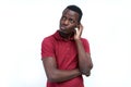 A young black man with a thoughtful expression, scratching his h Royalty Free Stock Photo