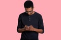 Young black man uses mobile phone, checking social media on smartphone. Handsome female wears casual jumper, holds his gadget, Royalty Free Stock Photo