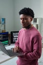 Young Black Man Using Laptop While Standing in Office Workspace Royalty Free Stock Photo