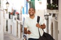 Young black man walking and listening to music with earphones and smart phone Royalty Free Stock Photo