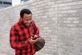 Young black man walking with mobile phone and bag Royalty Free Stock Photo