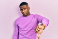 Young black man wearing casual pink sweater looking unhappy and angry showing rejection and negative with thumbs down gesture Royalty Free Stock Photo