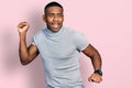 Young black man wearing casual t shirt dancing happy and cheerful, smiling moving casual and confident listening to music Royalty Free Stock Photo