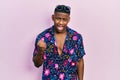 Young black man wearing hawaiian shirt and sunglasses angry and mad raising fist frustrated and furious while shouting with anger Royalty Free Stock Photo