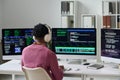 Young Black Man Wearing Headphones Coding Software on Multiple Monitors Royalty Free Stock Photo