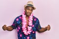 Young black man wearing summer shirt and hawaiian lei looking confident with smile on face, pointing oneself with fingers proud Royalty Free Stock Photo