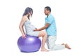 A young black man helps his white wife with birth pain with a ball. Partnered birth, partnered delivery. Isolated white