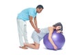 A young black man helps his white wife with birth pain with a ball. Partnered birth, partnered delivery. Isolated white