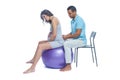 A young black man helps his white wife with birth pain with a ball. Partnered birth, partnered delivery. Isolated white