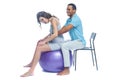 A young black man helps his white wife with birth pain with a ball. Partnered birth, partnered delivery. Isolated white