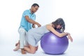 A young black man helps his white wife with birth pain with a ball. Partnered birth, partnered delivery. Isolated white