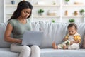 Young Black Mom Working Online On Computer With Little Baby Playing Around Royalty Free Stock Photo