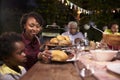 Young black mother serving her son food at a family barbecue