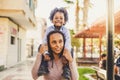 Young black mother and son together have fun and enjoy the playhood at the park mommy take litthe boy on her shoulder - happiness