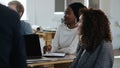 Young black professional corporate manager woman listening at team discussion at table in multiethnic modern office. Royalty Free Stock Photo