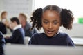 Young black schoolgirl using a laptop computer sitting at desk in a primary school classroom, front view, close up Royalty Free Stock Photo