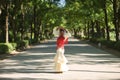 Young black and South American woman in a beige gypsy flamenco suit and red shawl, dancing in a park in the city of Seville in Royalty Free Stock Photo