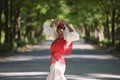 Young black and South American woman in a beige gypsy flamenco suit and red shawl, dancing in a park in the city of Seville in Royalty Free Stock Photo