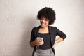 Woman with afro hairstyle checking smart cell phone and smilling. Technology, social media, addiction, network concept Royalty Free Stock Photo