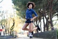 Young black woman with afro hairstyle jumping in urban background