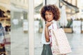 Young black woman, afro hairstyle, looking at a shop window Royalty Free Stock Photo