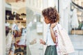 Young black woman, afro hairstyle, looking at a shop window Royalty Free Stock Photo