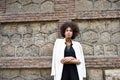 Young black woman with afro hairstyle standing in urban background Royalty Free Stock Photo