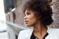 Young black woman with afro hairstyle standing in urban background Royalty Free Stock Photo