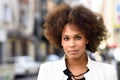 Young black woman with afro hairstyle standing in urban background Royalty Free Stock Photo