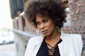 Young black woman with afro hairstyle standing in urban background Royalty Free Stock Photo