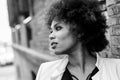 Young black woman with afro hairstyle standing in urban background Royalty Free Stock Photo