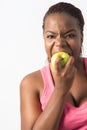 Young Black Woman biting a green apple Royalty Free Stock Photo