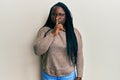 Young black woman with braids wearing casual clothes and glasses asking to be quiet with finger on lips Royalty Free Stock Photo