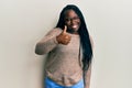 Young black woman with braids wearing casual clothes and glasses doing happy thumbs up gesture with hand Royalty Free Stock Photo