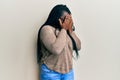 Young black woman with braids wearing casual clothes and glasses with sad expression covering face with hands while crying Royalty Free Stock Photo