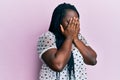 Young black woman with braids wearing casual clothes with sad expression covering face with hands while crying Royalty Free Stock Photo