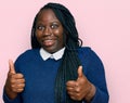 Young black woman with braids wearing casual clothes success sign doing positive gesture with hand, thumbs up smiling and happy Royalty Free Stock Photo