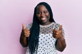 Young black woman with braids wearing casual clothes success sign doing positive gesture with hand, thumbs up smiling and happy Royalty Free Stock Photo