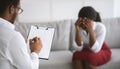 Young black woman crying on consultation with psychologist, communicating with mental health professional at office Royalty Free Stock Photo