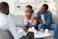 Young black woman crying at meeting with family counselor, husband comforting her