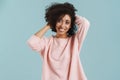 Young black woman with curly hair smiling and holding her head Royalty Free Stock Photo