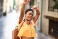 Young black woman is dancing on the street in Summer. Girl traveling alone.