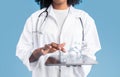 Young black woman doctor therapist in white coat uses tablet with blank screen and molecules Royalty Free Stock Photo