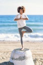 Young black woman doing yoga in the beach. Royalty Free Stock Photo