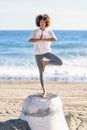 Young black woman doing yoga in the beach. Royalty Free Stock Photo