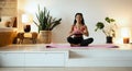 Young black woman doing yoga at home in the lotus position. Royalty Free Stock Photo