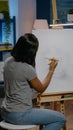 Young black woman drawing vase on white canvas in art studio Royalty Free Stock Photo