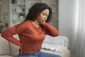 Young Black Woman Experiencing Neck Pain in a Cozy Living Room Royalty Free Stock Photo