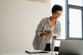 Young black woman drinking coffee while working with laptop Royalty Free Stock Photo